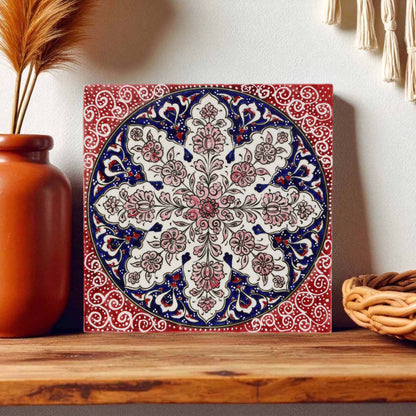 Decorative ceramic tile with intricate patterns on a wooden shelf