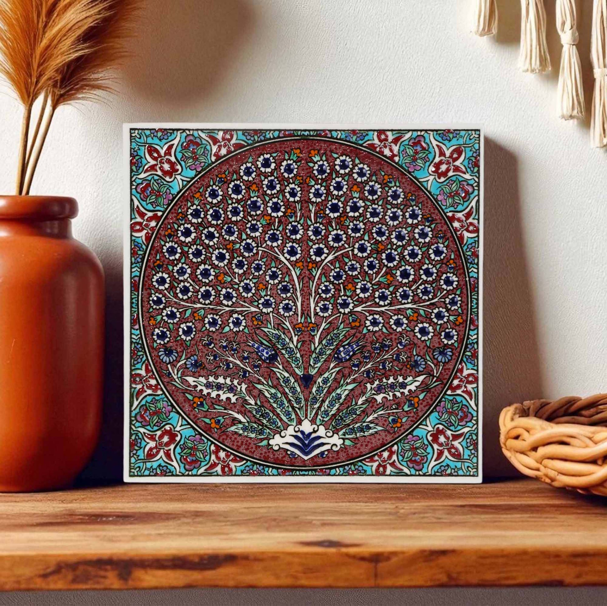 Decorative ceramic tile with floral pattern on a wooden shelf