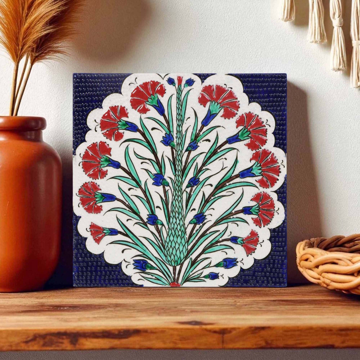 Decorative ceramic tile with floral pattern on a wooden shelf