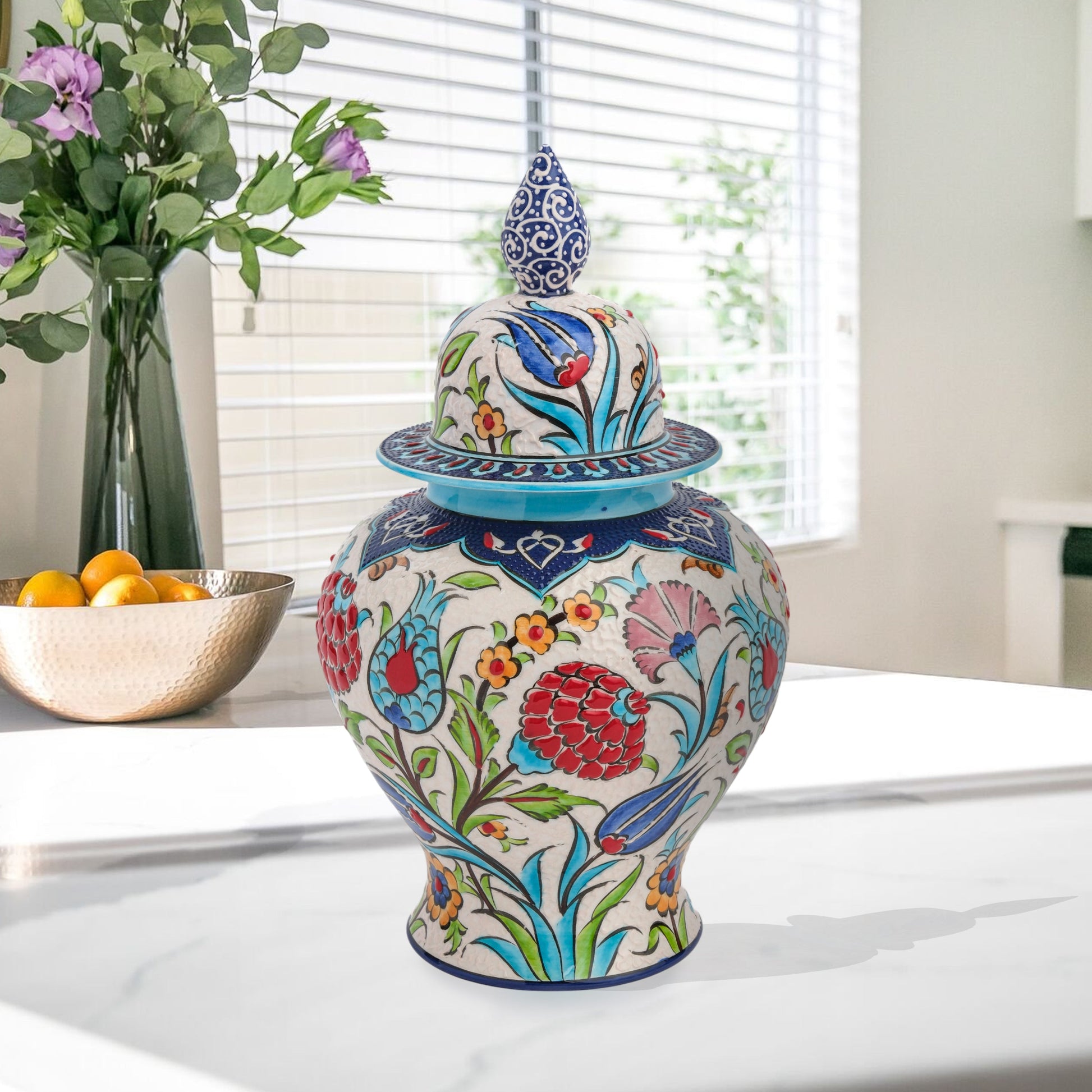 Hand-painted Floral Festival ceramic jar with red carnations, blue tulips & yellow blossoms. Glossy artisan jar with cobalt finial lid, perfect décor or gift.