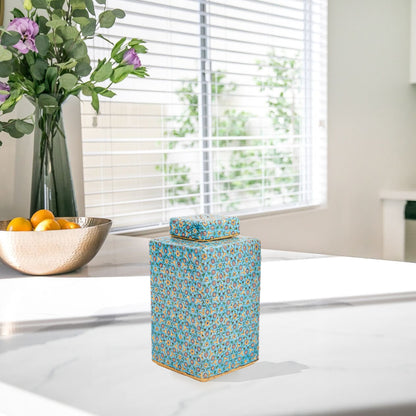 Hand-painted Golden Blossom ceramic jar with turquoise base and gold floral motifs. Square lidded design, artisan-made, perfect for décor, tea, or gifts.