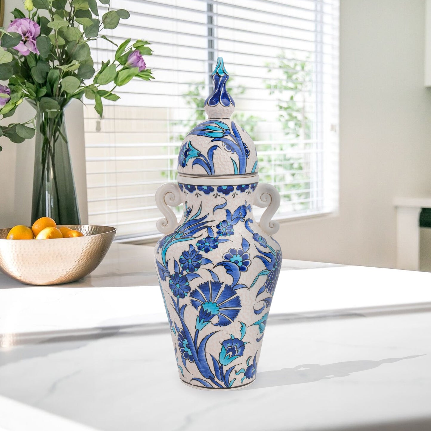 Hand-painted Azure Blossom ceramic jar with Turkish blue floral motifs and turquoise accents. Features handles and finial lid, perfect décor or collector’s gift.