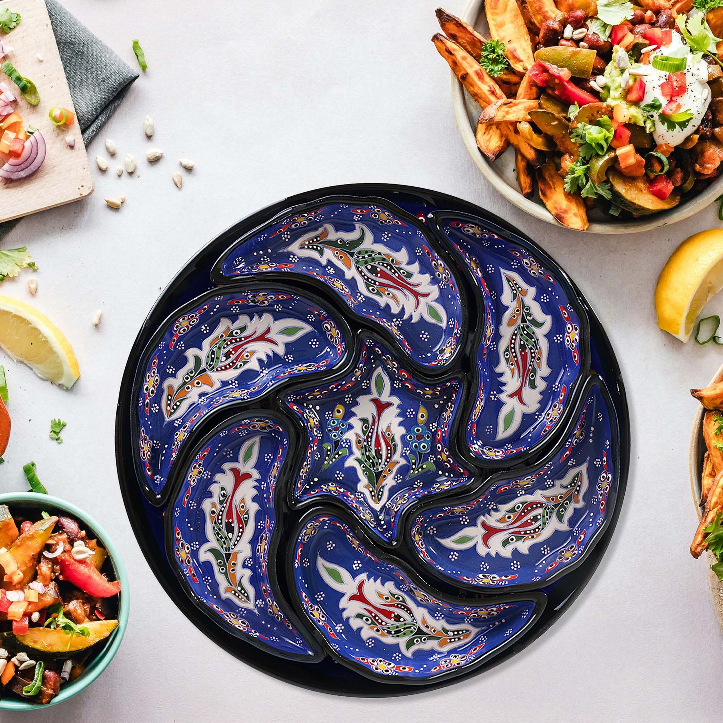 Decorative blue and black snack serving tray set with food on a white table