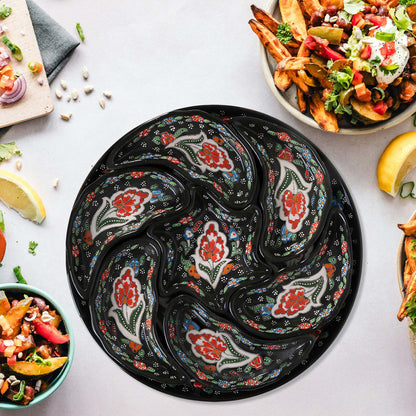 Set of black ceramic snack serving trays with floral patterns on a light gray surface.