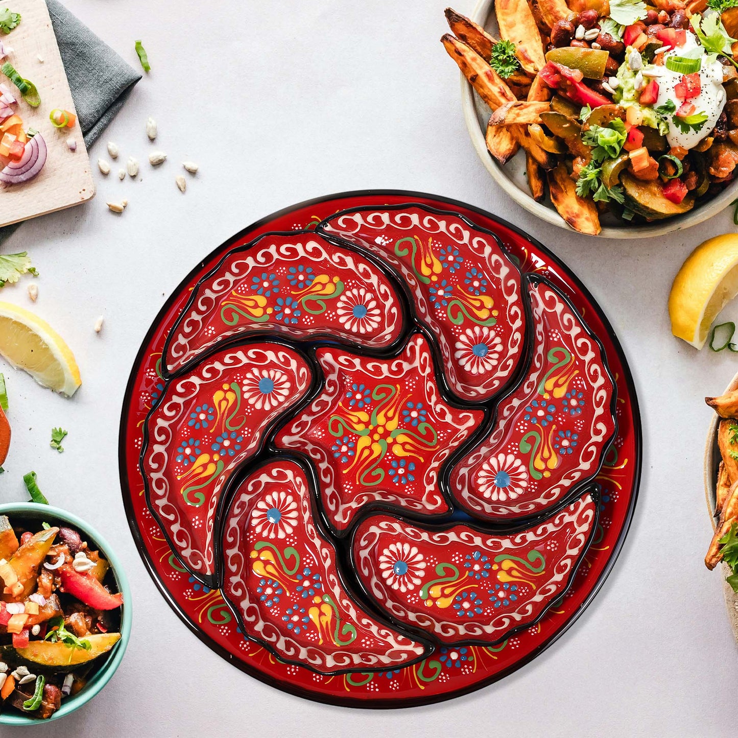 Decorative red snack serving tray set with intricate patterns on a table with food.