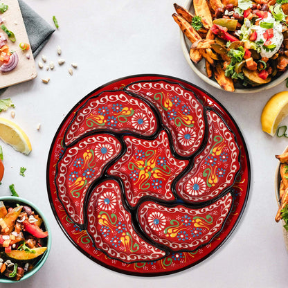 Decorative red snack serving tray set with intricate patterns on a table with food.