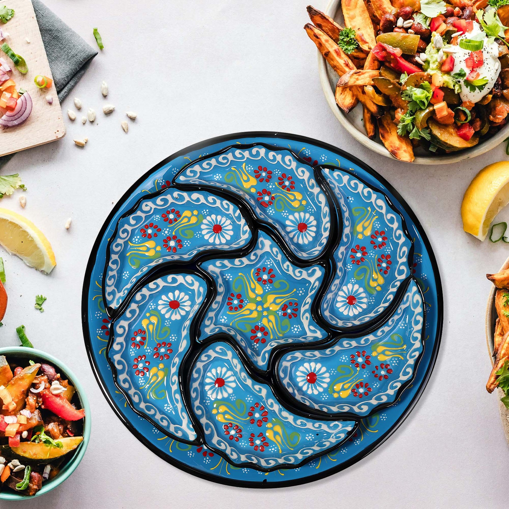 Decorative blue snack serving tray set with floral patterns on a table with food.