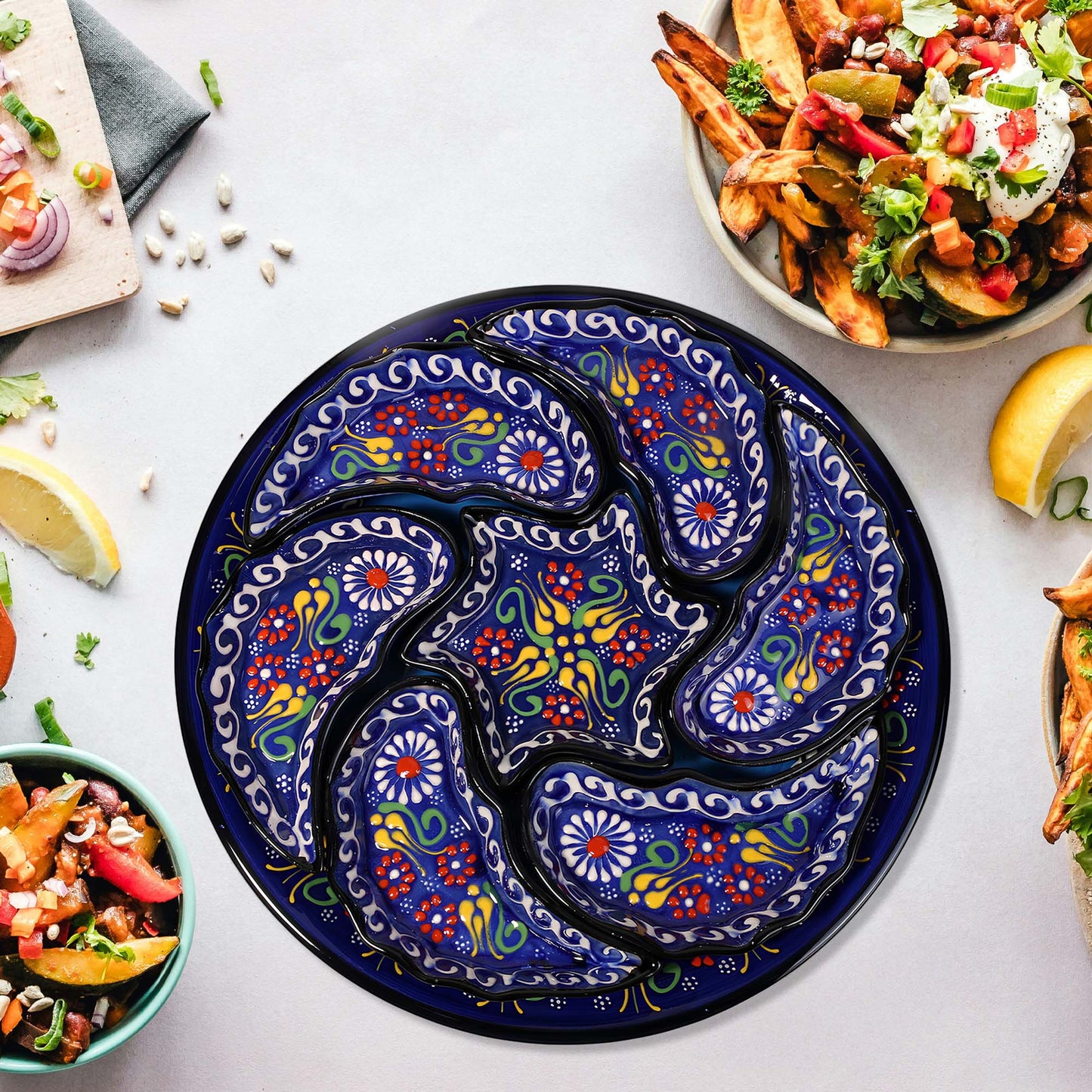 Decorative blue snack serving tray set with floral patterns on a table with food.