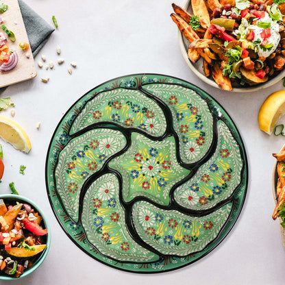 Decorative green snack serving tray set with floral patterns on a table with food.