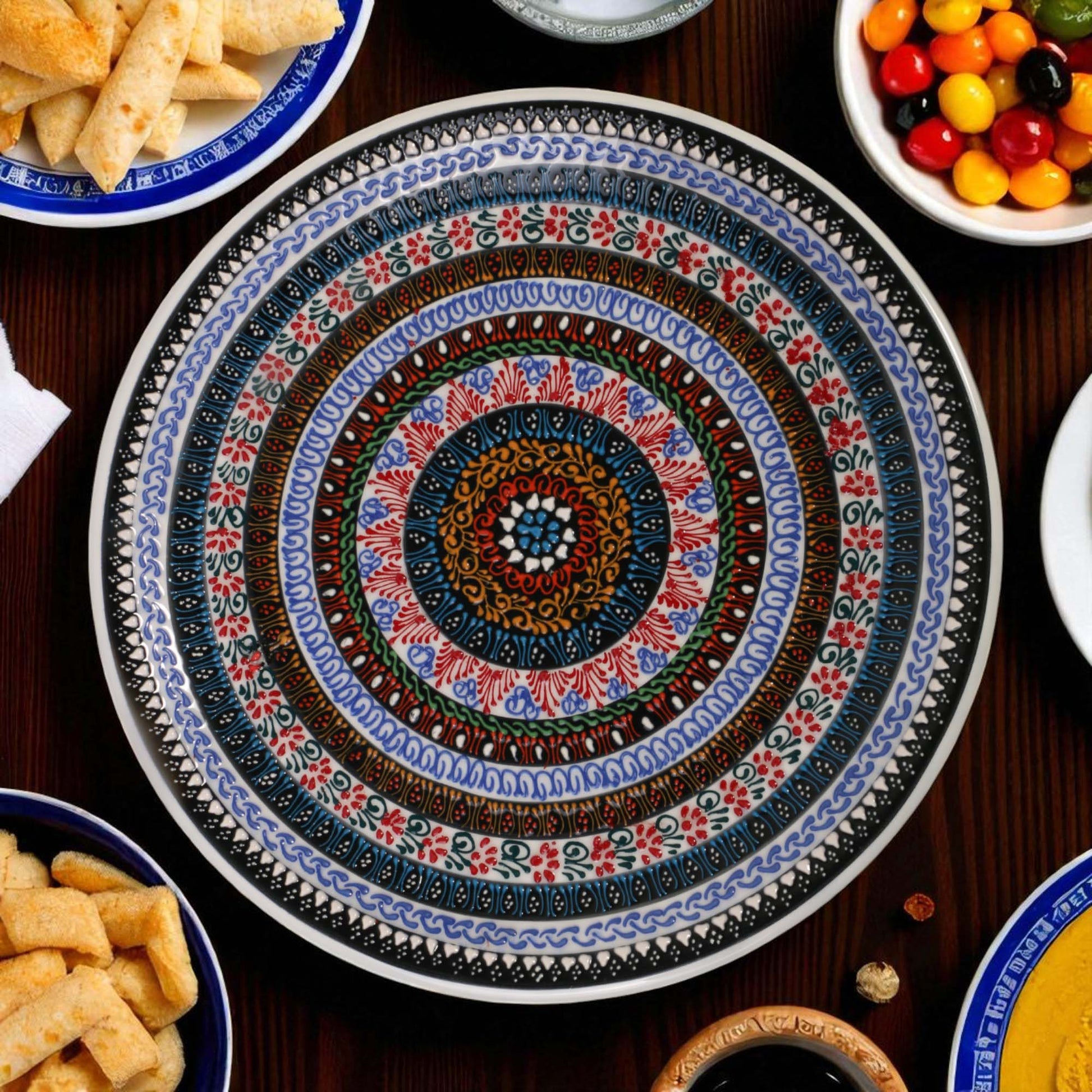 Decorative ceramic plate with intricate patterns on a table with snacks