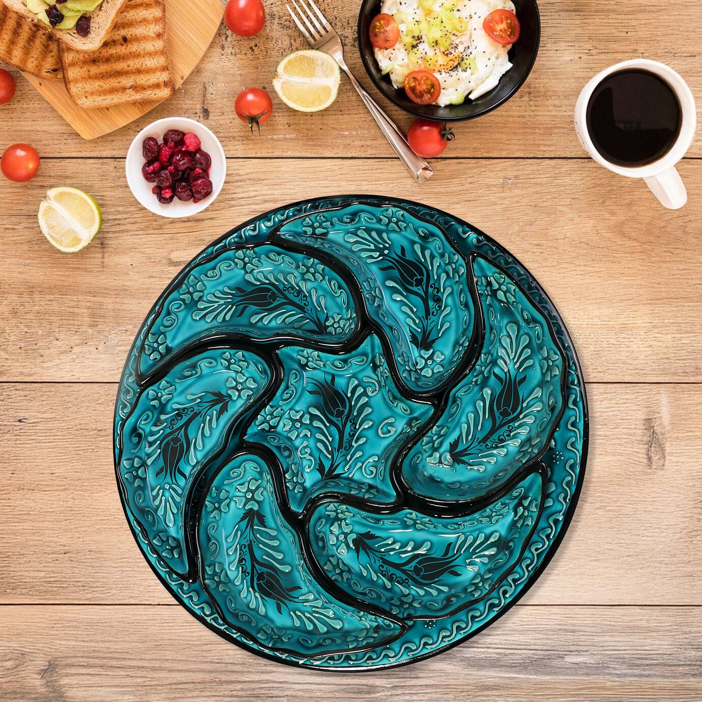 Teal dragon-shaped snack serving tray set on a wooden table with food items.
