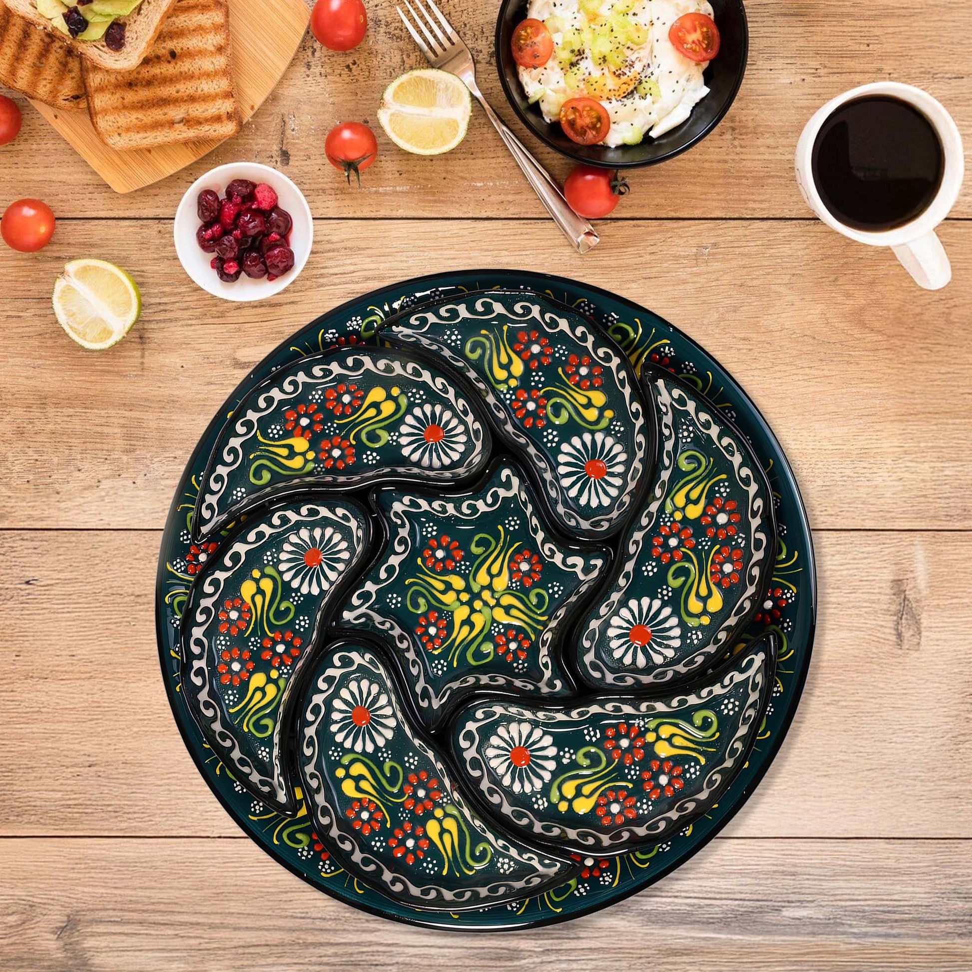 Decorative round snack serving tray set with floral patterns on a wooden table with food and coffee.
