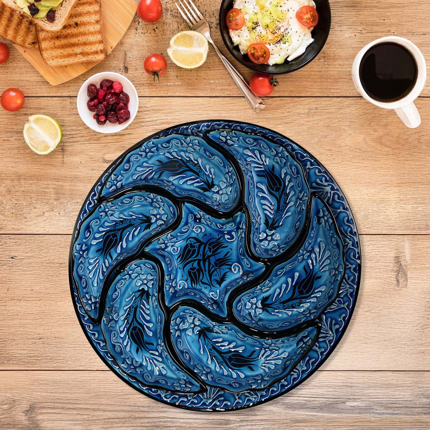 Blue decorative snack serving tray set with tulip design on a wooden table with food items.