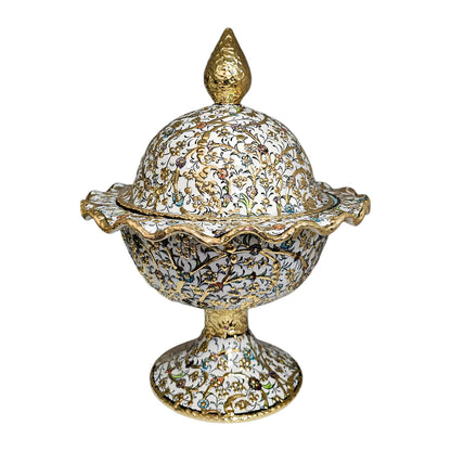 Decorative sugar bowl with intricate gold and white design on a white background