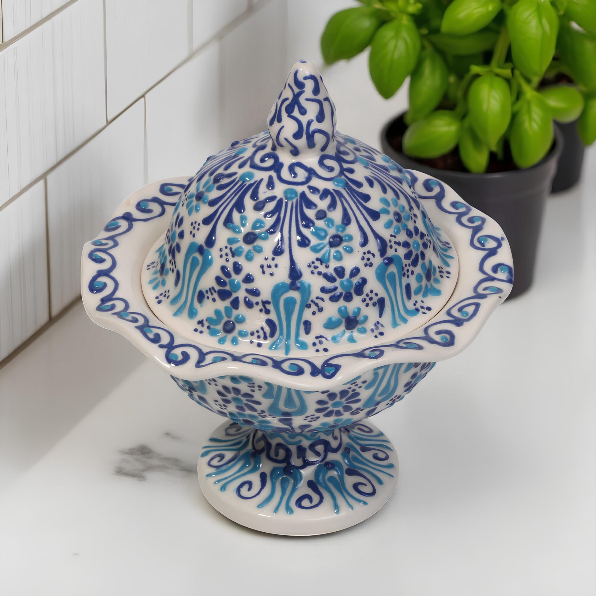 Decorative ceramic sugar bowl with blue and white patterns on a white surface.