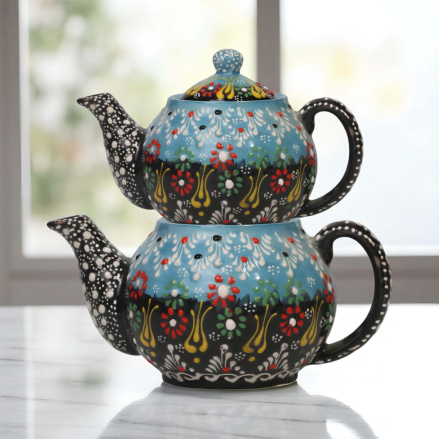 Colorful ceramic teapot with floral patterns on a light surface.