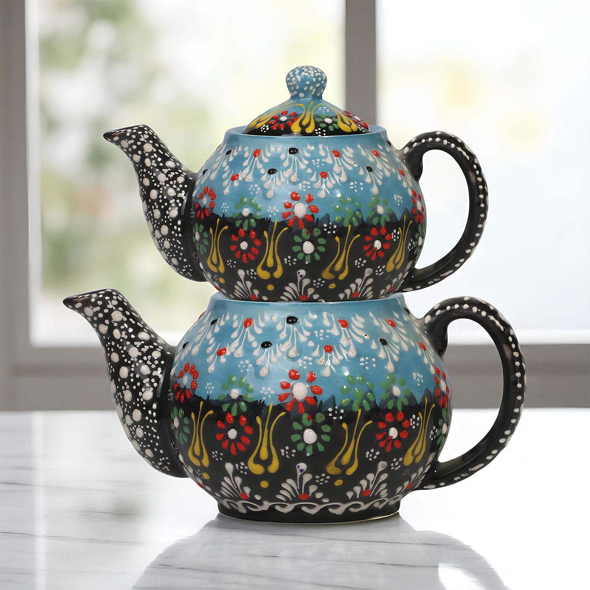 Colorful ceramic teapot with floral patterns on a light surface.