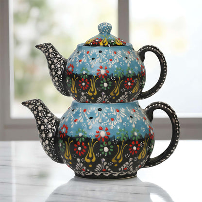 Colorful ceramic teapot with floral patterns on a light surface.
