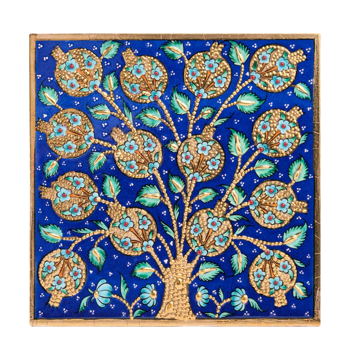 A handmade ceramic tile featuring a blue pomegranate tree with golden fruit and turquoise floral accents on a deep blue background.