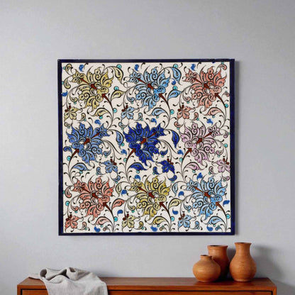 Decorative floral ceramic tile hanging on a wall above a wooden cabinet with vases.