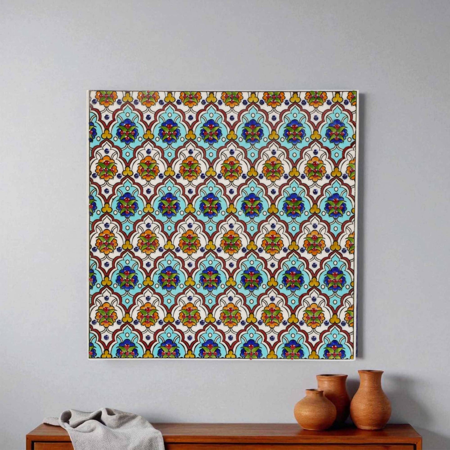 Decorative ceramic tile wall art with a colorful geometric pattern on a plain wall.