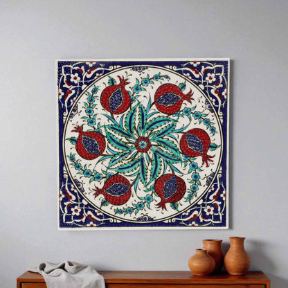Decorative ceramic tile with floral and pomegranate design on a plain wall.
