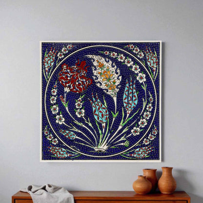 Decorative ceramic tile with floral design on a wall above a wooden cabinet.