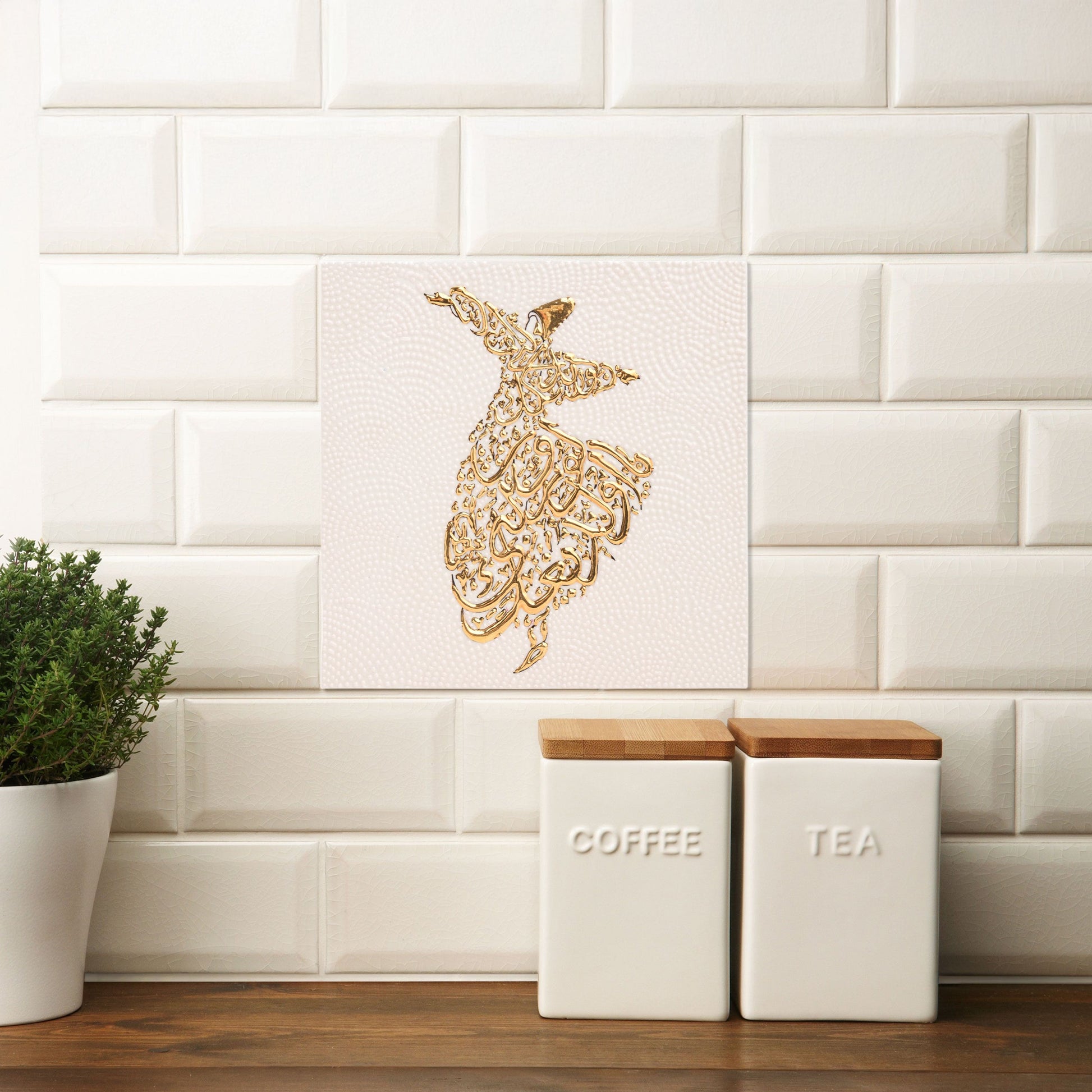 Decorative Arabic calligraphy ceramic tile on a white tiled wall with kitchen storage containers.