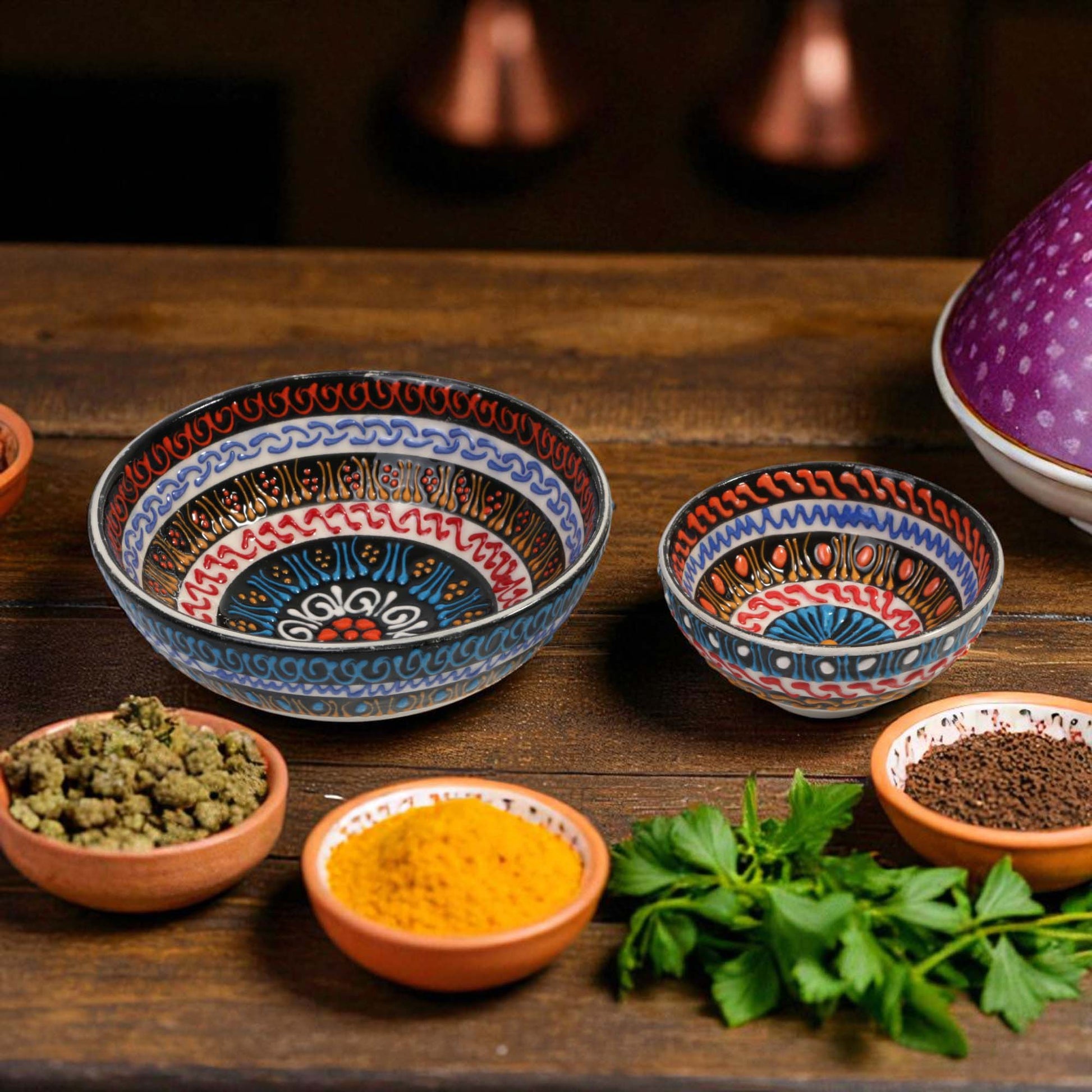 Decorative ceramic bowls with spices and herbs on a wooden surface