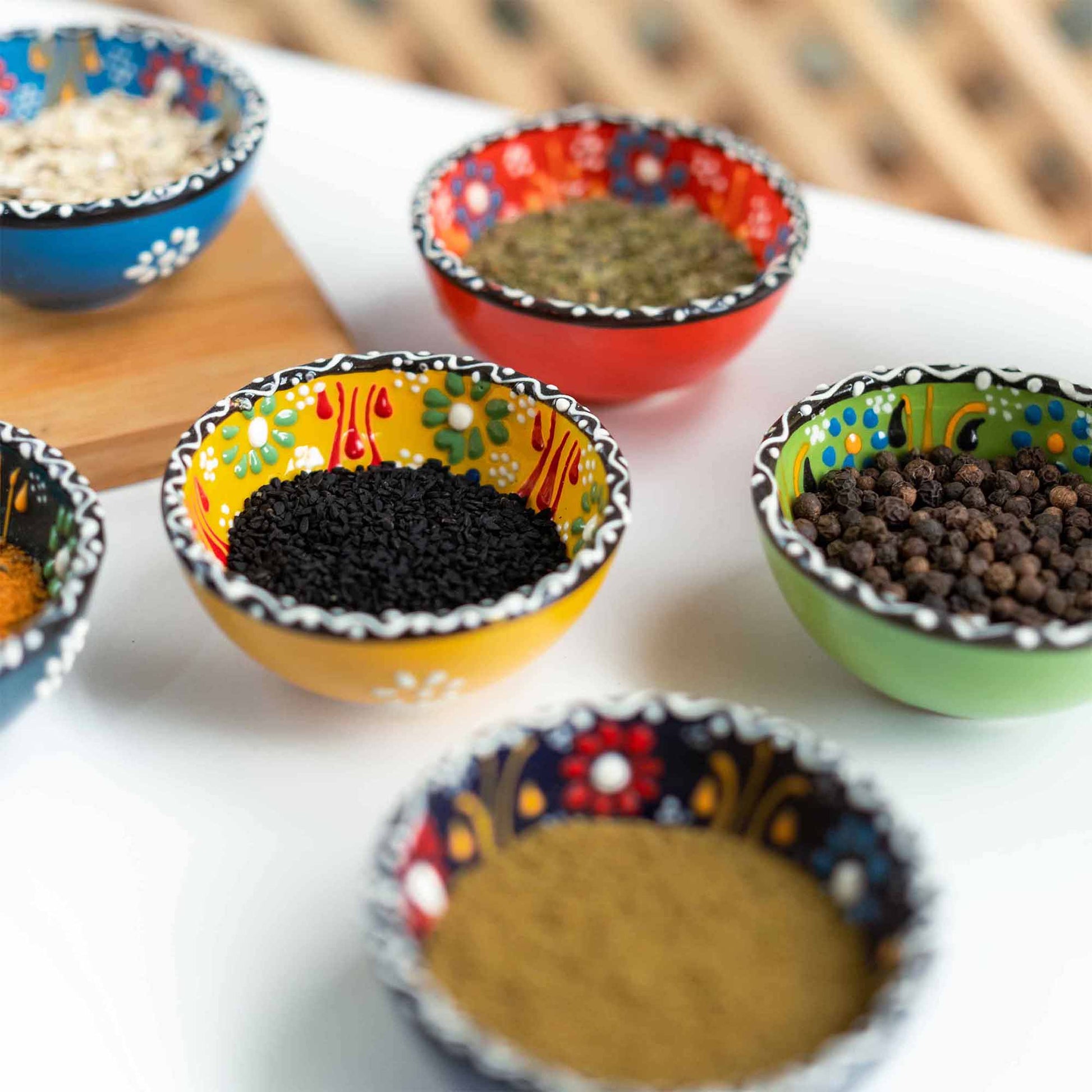 Colorful sauce bowls with spices on a white surface