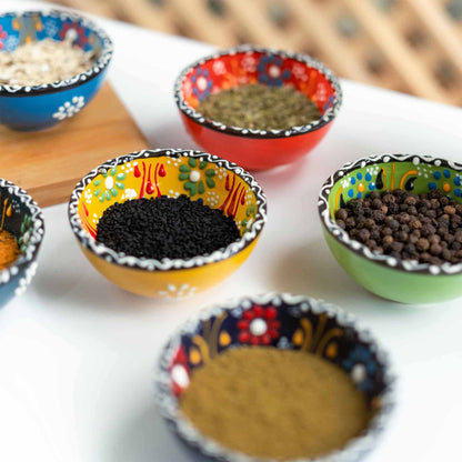 Colorful sauce bowls with spices on a white surface