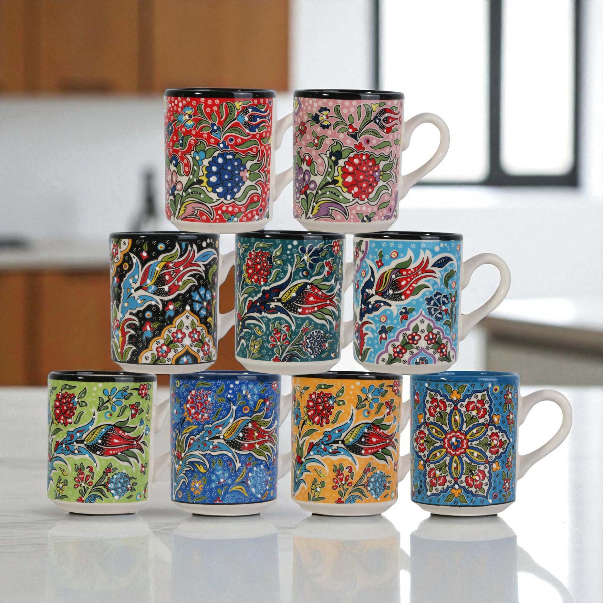 Set of colorful ceramic tea mugs stacked on a kitchen counter