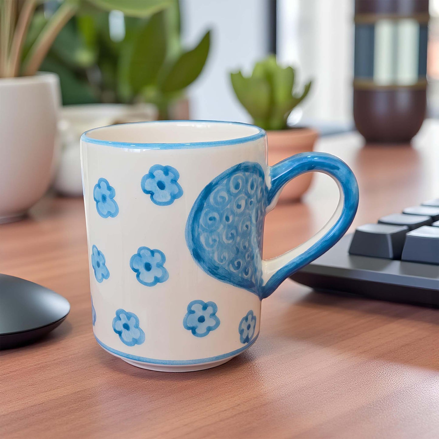 Ceramic mug with blue floral patterns on a wooden desk