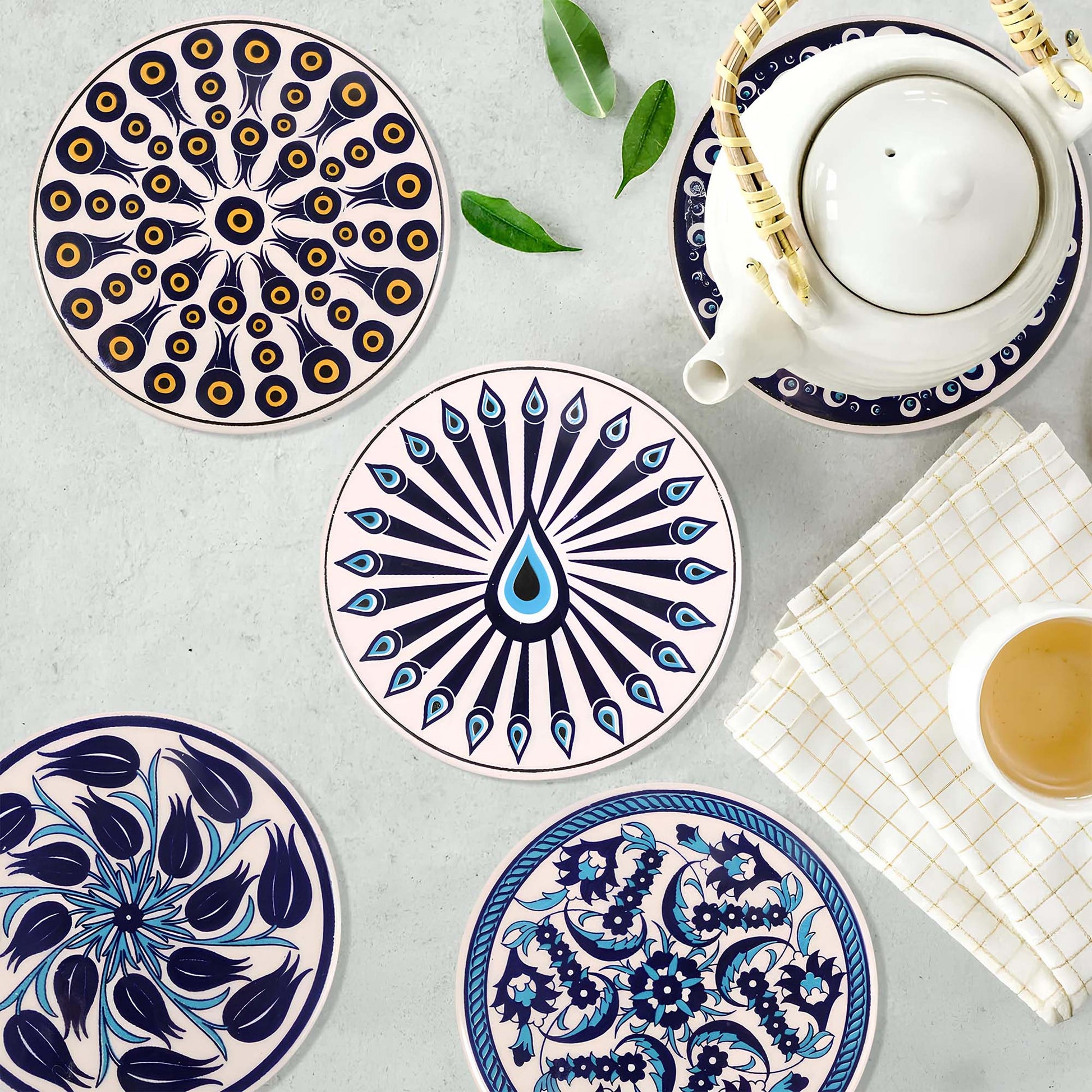 Set of decorative ceramic trivets with intricate patterns on a light gray surface.