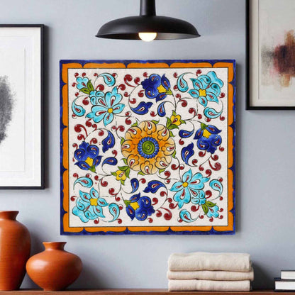 Decorative floral ceramic tile on a wall with vases and towels below