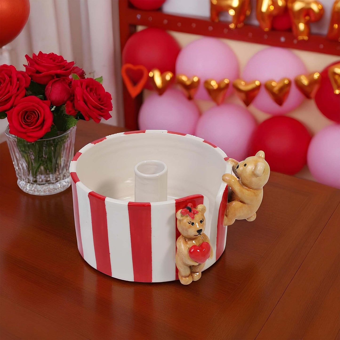 Decorative paper towel holder with teddy bears and a heart, surrounded by balloons and flowers on a wooden surface.
