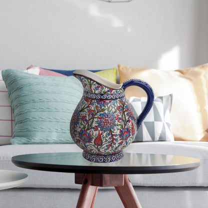 Hand-painted ceramic pitcher with Iznik-inspired tulips, carnations & leaves in red, blue & green. Decorative artisan piece, perfect for display.