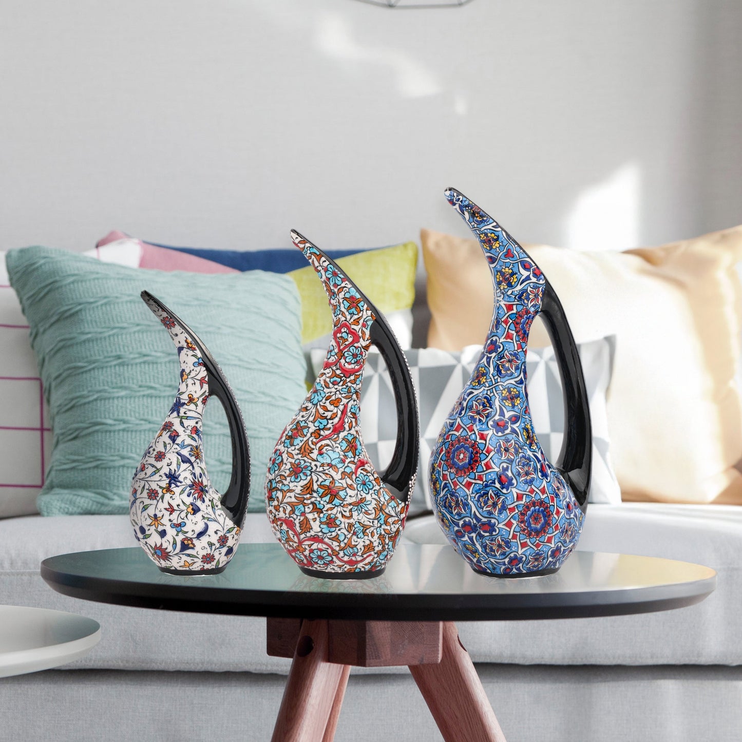 Set of 3 hand-painted ceramic ewers with Ottoman floral motifs in unique color palettes. Glossy artisan pieces with black handles, perfect décor or gifts.