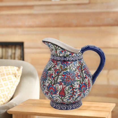 Hand-painted ceramic pitcher with Iznik-inspired tulips, carnations & leaves in red, blue & green. Decorative artisan piece, perfect for display.