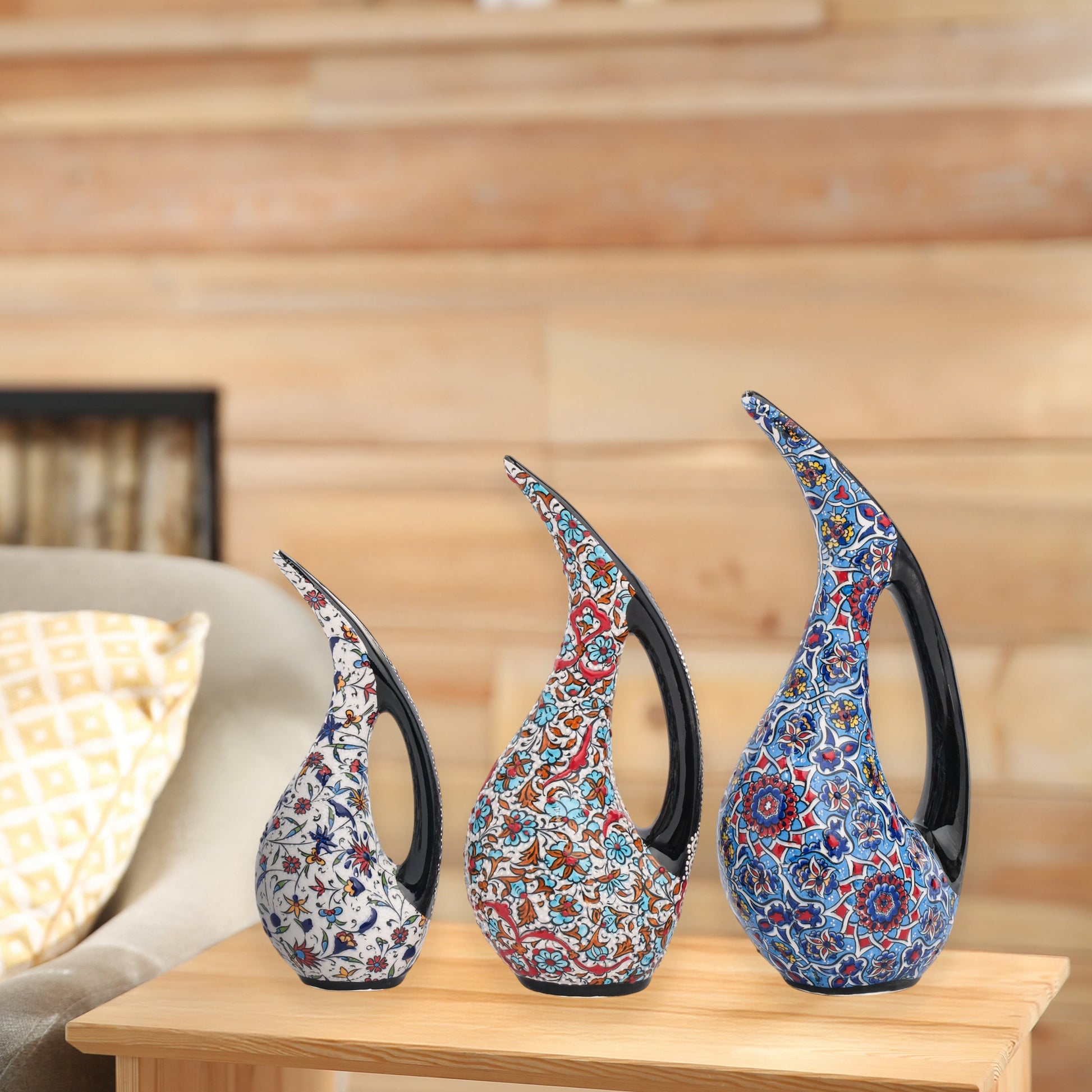 Set of 3 hand-painted ceramic ewers with Ottoman floral motifs in unique color palettes. Glossy artisan pieces with black handles, perfect décor or gifts.