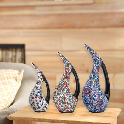 Set of 3 hand-painted ceramic ewers with Ottoman floral motifs in unique color palettes. Glossy artisan pieces with black handles, perfect décor or gifts.
