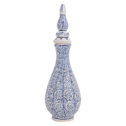 A tall, hand-painted Turkish ceramic vase with a white base and blue floral vine motif, featuring a pointed lid.