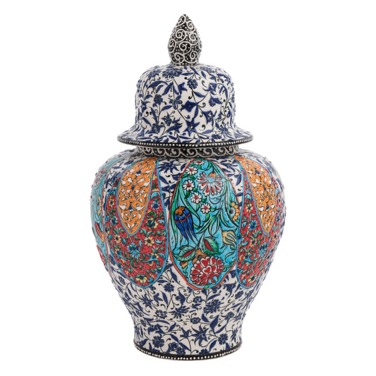 A hand-painted ceramic jar with a lid, featuring colorful floral patterns and bird motifs on a blue-and-white botanical base, with a decorative finial on the lid.