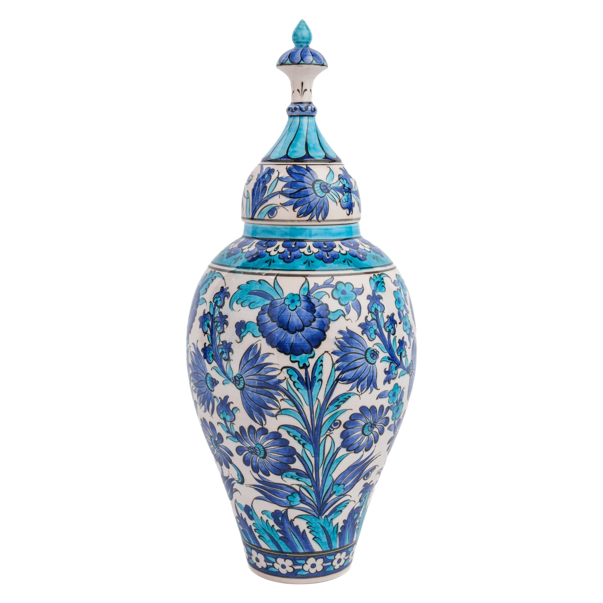 A tall, slender handmade ceramic jar with a lid, featuring intricate hand-painted floral motifs in blue and turquoise shades on a white background.