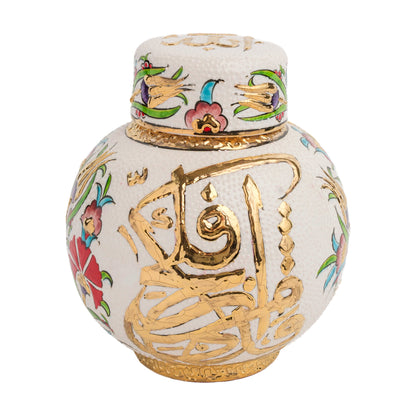 A handcrafted ceramic jar with a gold calligraphy design, featuring Ottoman floral motifs and radiant gold Arabic calligraphy, on a melon-shaped body with a lid.
