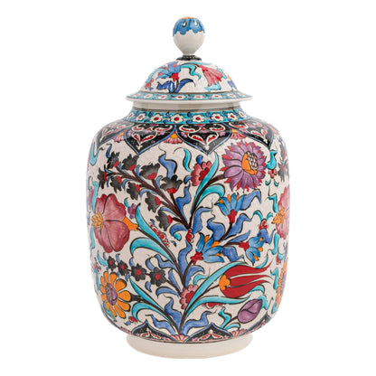 A hand-painted ceramic jar with a lid, featuring a colorful floral pattern with rich purples, reds, turquoise, and oranges against a traditional Ottoman motif.