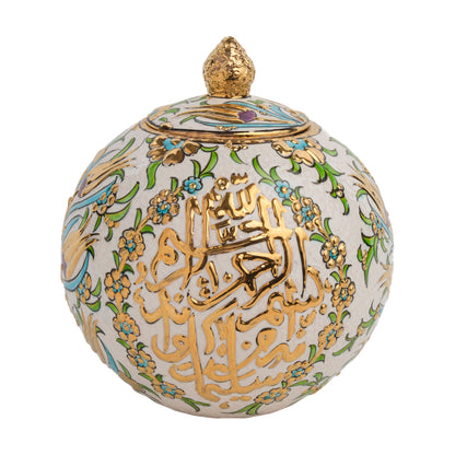 A spherical ceramic jar with gold Arabic calligraphy and floral patterns, featuring a golden finial on the lid.