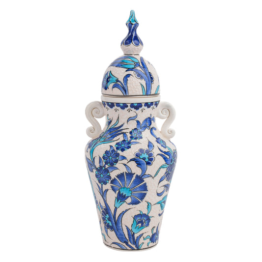 A hand-painted ceramic jar with a lid, featuring blue floral patterns and turquoise details, along with elegant side handles and a sculpted finial.