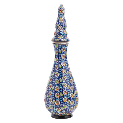 A handmade ceramic jar with a teardrop silhouette, featuring a navy blue base and vibrant floral patterns in white, yellow, and red, with a sculpted ornamental lid.