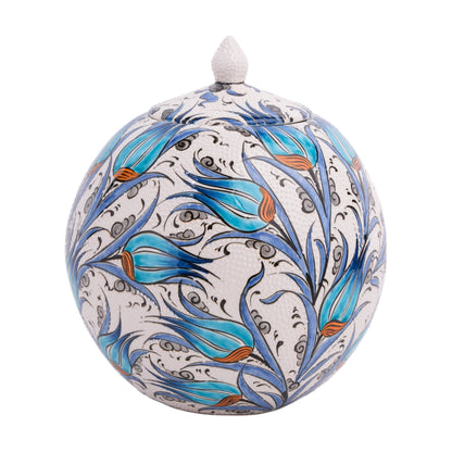 A hand-painted ceramic jar with a turquoise tulip design, featuring black swirling floral detailing on a white background, topped with a lid.